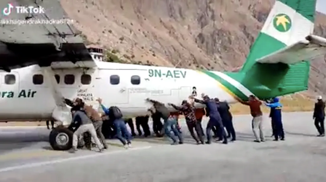 Au Népal, des passagers poussent un avion tombé en panne